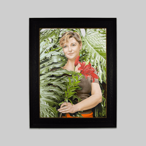 Original artwork Clare in the Philodendron by Jan Frank, framed in dark wood with green leaves.