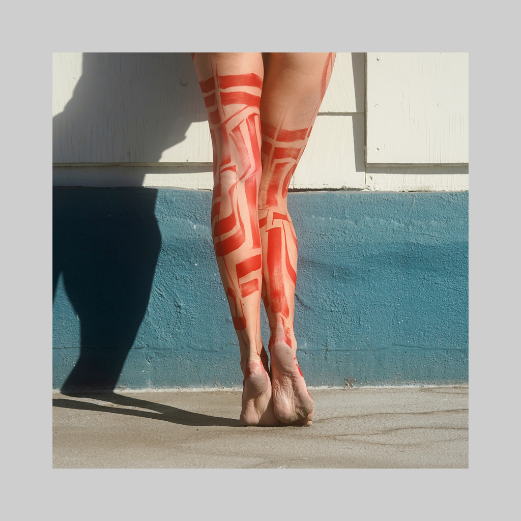 Red Boots photograph by VEFA Gallery: legs painted with red abstract patterns against a white wall.