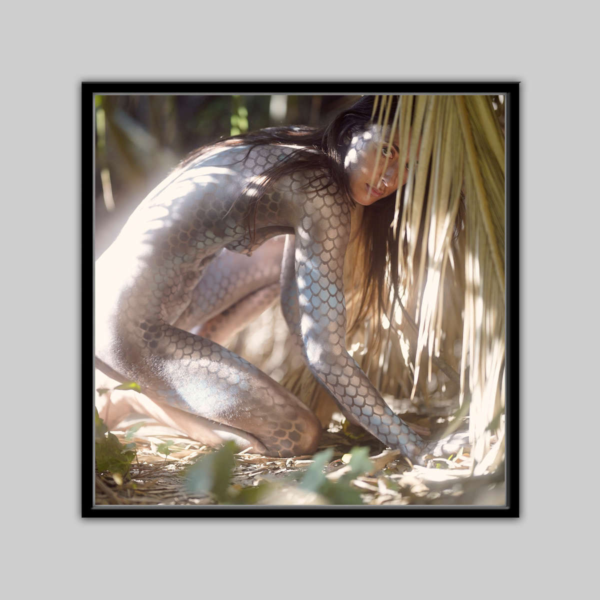 Slither print by Paul Roustan, close-up of a person with snake-scale body paint among palm fronds.